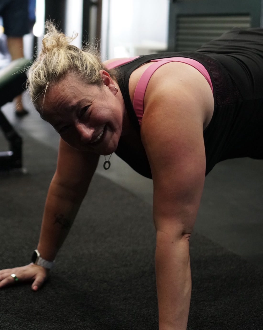 A member smiling through a push up during a session at Ten Percent Performance in Cranford, New Jersey